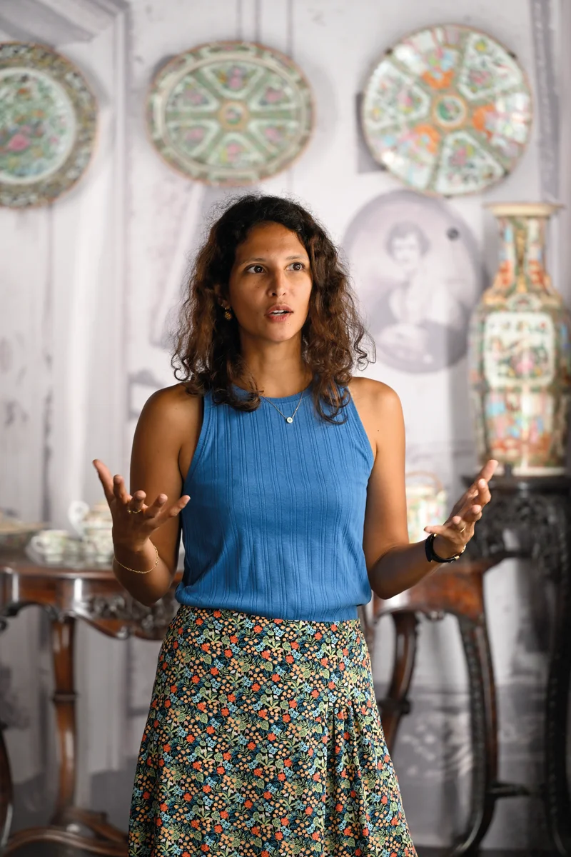 Anne-Laure Garaïos, directrice du MADOI Réunion, souriante devant une œuvre d'art.