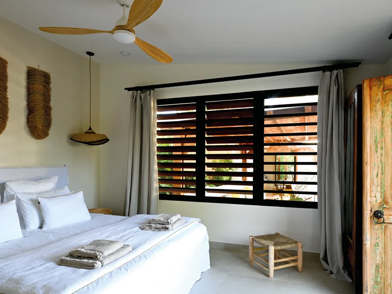 Chambre cocooning et ses jalousies créoles.