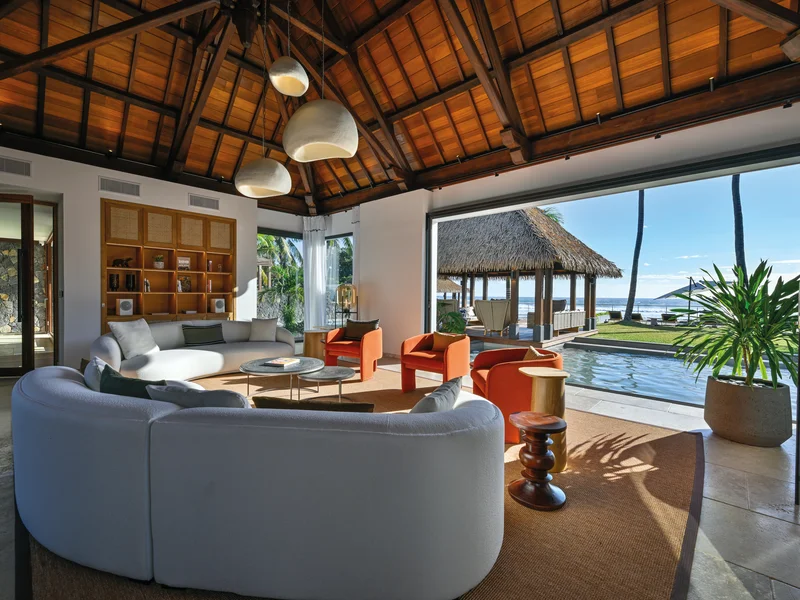 Intérieur lumineux d'une villa tropicale avec vue sur piscine et océan