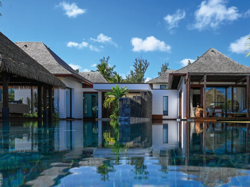 Patio verdoyant d'une villa avec bassin d'eau et plantes tropicales