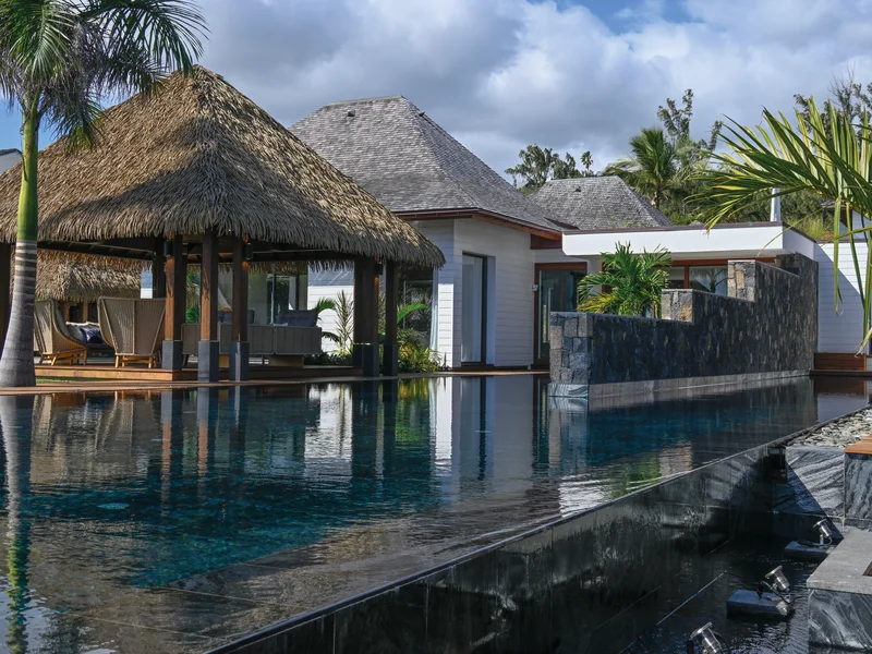 Jardin tropical luxuriant avec cocotiers et flamboyants autour de la villa