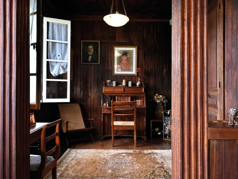 Intérieur de la maison créole Auguste, salon avec carrelage vintage et bois précieux.